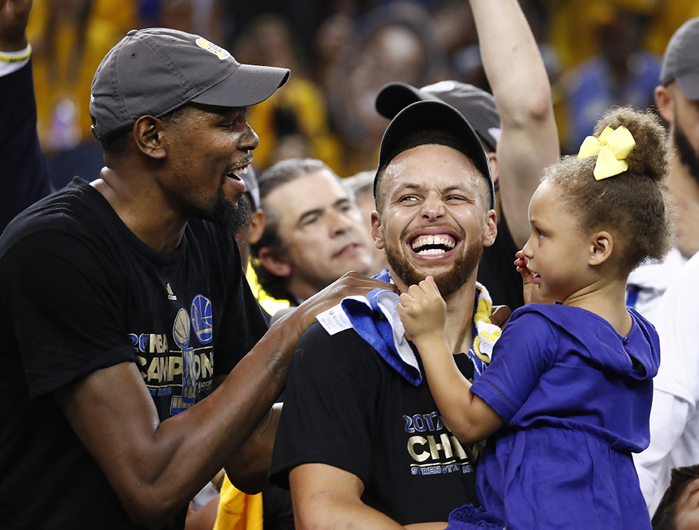 Kevin Durant and Stephen Curry
Cleveland Cavaliers at Golden State Warriors, Oakland, USA - 12 Jun 2017
Golden State Warriors player Kevin Durant (L) laughs with teammate Stephen Curry (C) holding one of his daughters while celebrating after winning the NBA Finals against the Cleveland Cavaliers in game five of the NBA Finals.