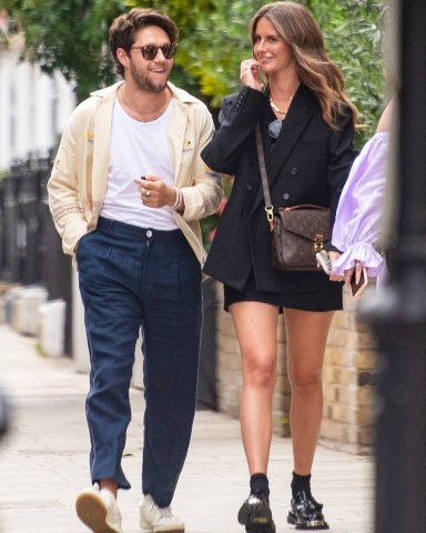 London, UNITED KINGDOM  - *EXCLUSIVE*  - 1D star Niall Horan looks loved up with girlfriend Amelia as he takes her dad and mum out for Fathers Day lunch. The pair looked happy as they strolled arm in arm through Knightsbridge with her mum and dad and friend to Hawksmoor restaurant. Two surprised women did a double-take as they recognized the One Direction heartthrob. Niall wearing a £430 linen Bode shirt adorned with yachts and Navy linen trousers with white detailing, Amelia was dressed in a black blazer and black mini skirt with a Louis Vuitton bag and Sandro iron platform loafers priced £345. Amelia who left the restaurant with her parents first was seen posing up against a large door for a photo whilst waiting for Niall who was last to leave. The couple has been dating for 2 years and is said to be serious.Pictured: Niall Horan Amelia Woolley Paul WoolleyBACKGRID USA 20 JUNE 2022 USA: +1 310 798 9111 / usasales@backgrid.comUK: +44 208 344 2007 / uksales@backgrid.com*UK Clients - Pictures Containing ChildrenPlease Pixelate Face Prior To Publication*