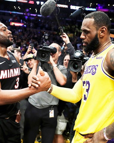 Miami Heat guard Dwyane Wade, left, shakes hands with Los Angeles Lakers' LeBron James at the end of an NBA basketball game Monday, Dec. 10, 2018, in Los Angeles. (AP Photo/Marcio Jose Sanchez)