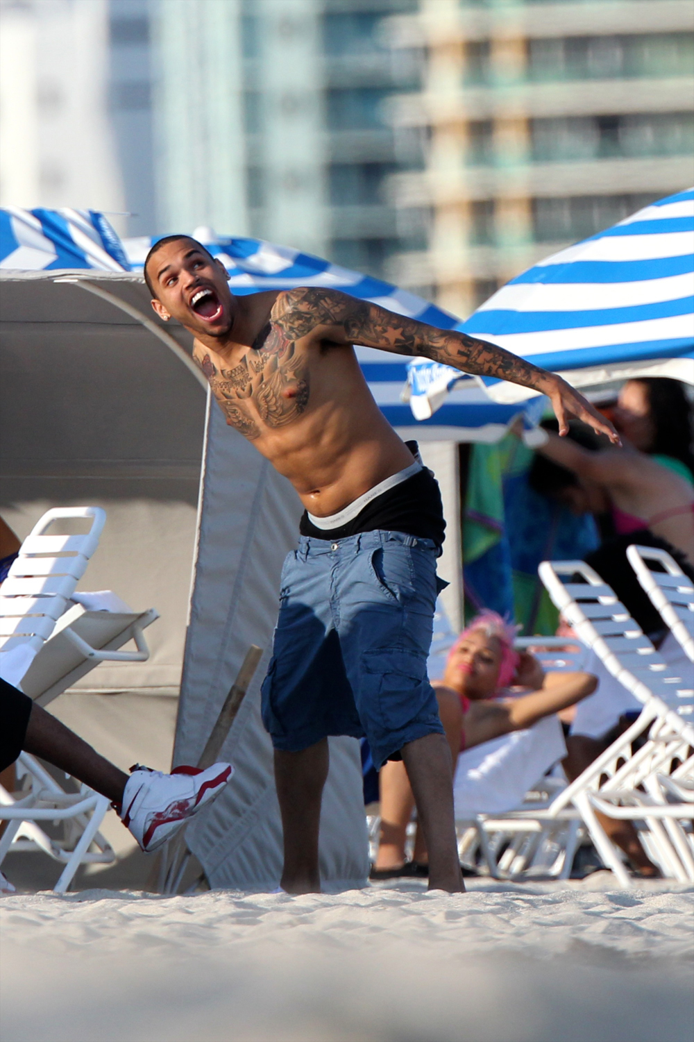 Chris Brown shirtless playing with seagulls at the beach in Miami