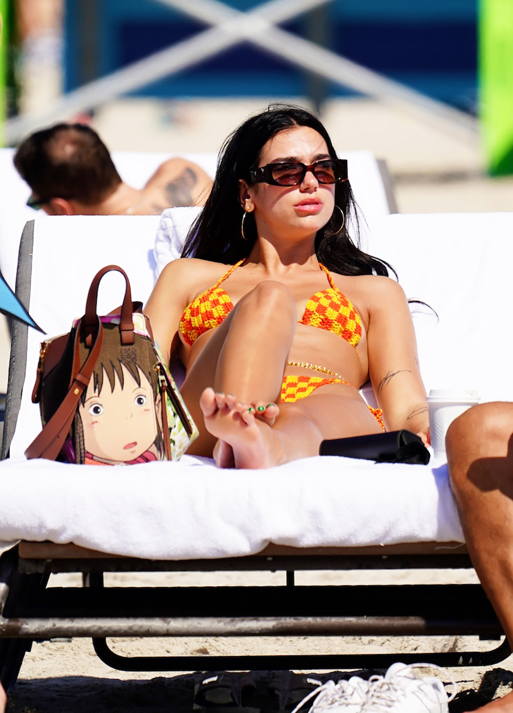 Dua Lipa hits the beach in a crocheted bikini after opening "Future Nostalgia" tour in Miami. The newly single British hitmaker kicked back with with her parents Dukagjin and Anesa on Thursday the morning after rocking the stage during the first show in her world tour. She showed off her flawless bikini body in the eye catching yellow and orange swimsuit as she relaxed on a lounger at her upscale oceanfront hotel. Dua carried her belongings in a striking anime inspired print tote by Spanish luxury label LoewePictured: Dua LipaRef: SPL5288864 100222 NON-EXCLUSIVEPicture by: Pichichipixx.com / SplashNews.comSplash News and PicturesUSA: +1 310-525-5808London: +44 (0)20 8126 1009Berlin: +49 175 3764 166photodesk@splashnews.comWorld Rights