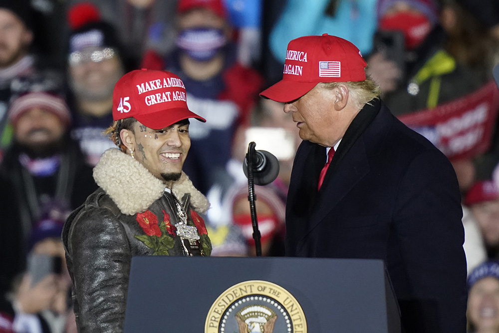 President Donald Trump brings rapper Lil Pump to the podium during a campaign event early Tuesday, Nov. 3, 2020, in Grand Rapids, Mich. (AP Photo/Carlos Osorio)