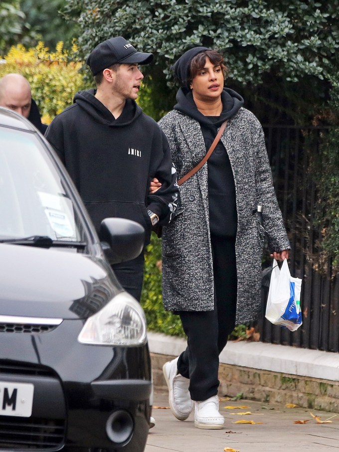 Nick Jonas and Priyanka Chopra Jonas wearing black hats