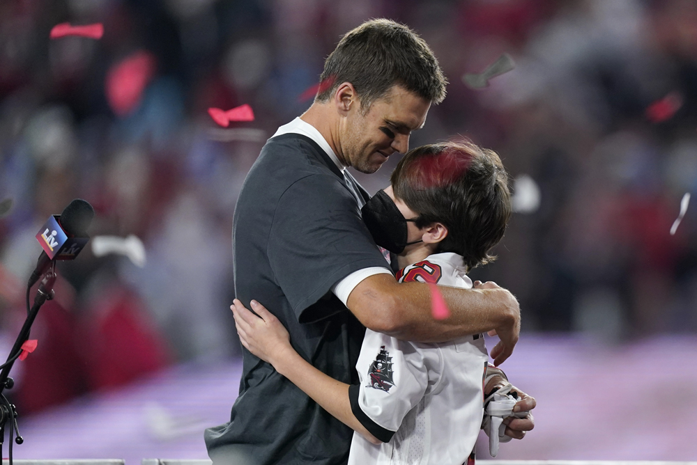 Tampa Bay Buccaneers quarterback Tom Brady embraces his son after defeating the Kansas City Chiefs in the NFL Super Bowl 55 football game Sunday, Feb. 7, 2021, in Tampa, Fla. The Buccaneers defeated the Chiefs 31-9 to win the Super Bowl. (AP Photo/Mark Humphrey)