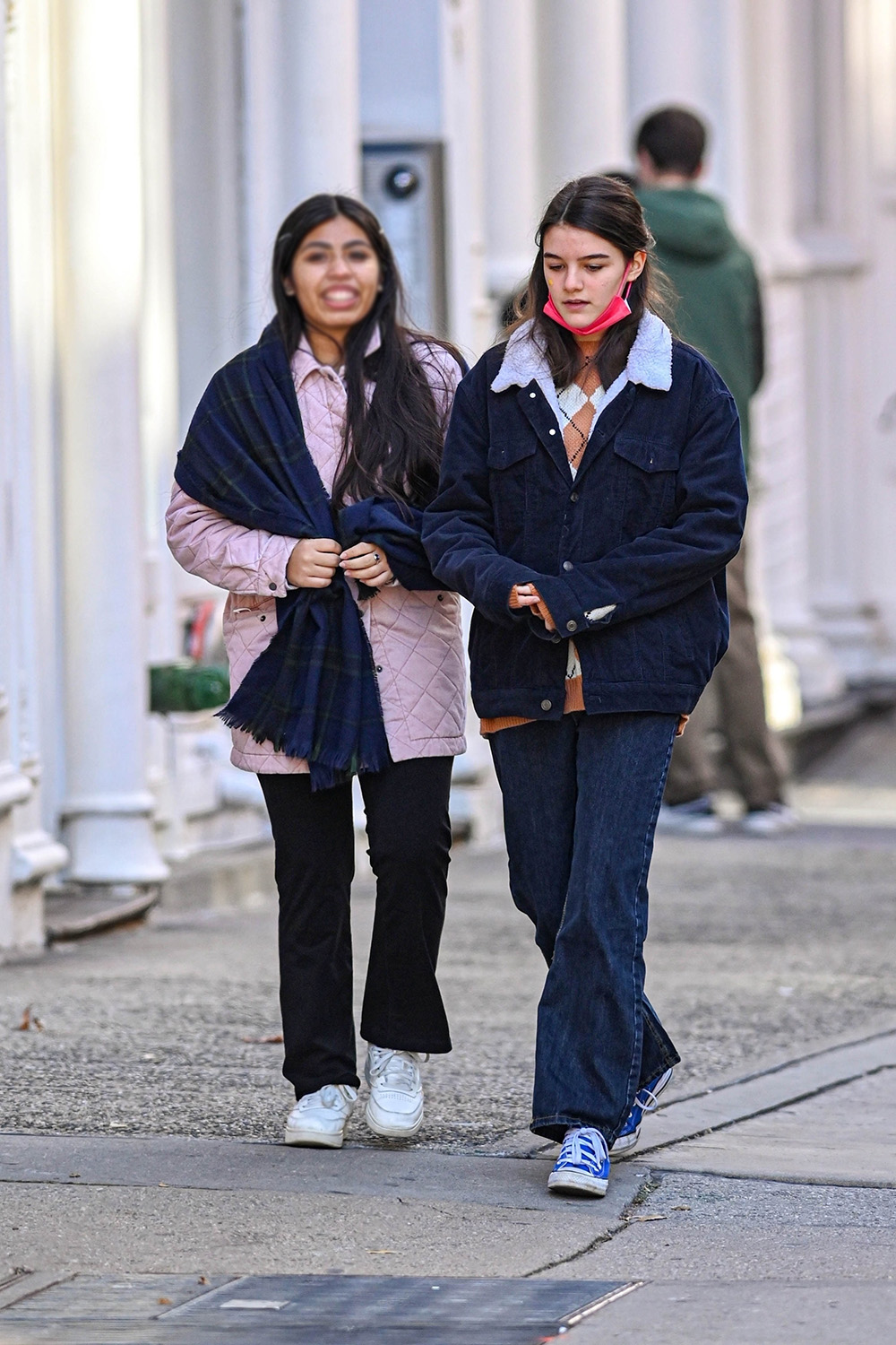 Grown up Suri Cruise can't help but smile while enjoying her neighborhood walk with a friend in NYC