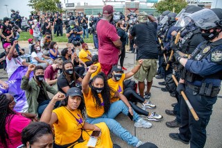 Tiffany Hicks, from left, Yandy Smith and Porsha Williams sit down in front of police during the Good Trouble Tuesday march for Breonna Taylor, on Tuesday, Aug. 25, 2020, in Louisville, Ky. (Amy Harris/Invision/AP)