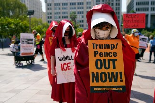 Demonstrators wear costumes and hold signs during a Women's March Saturday, Oct. 17, 2020, in Los Angeles. Thousands of women rallied in U.S. cities, to oppose President Donald Trump and his fellow Republican candidates in the Nov. 3 elections. (AP Photo/Marcio Jose Sanchez)