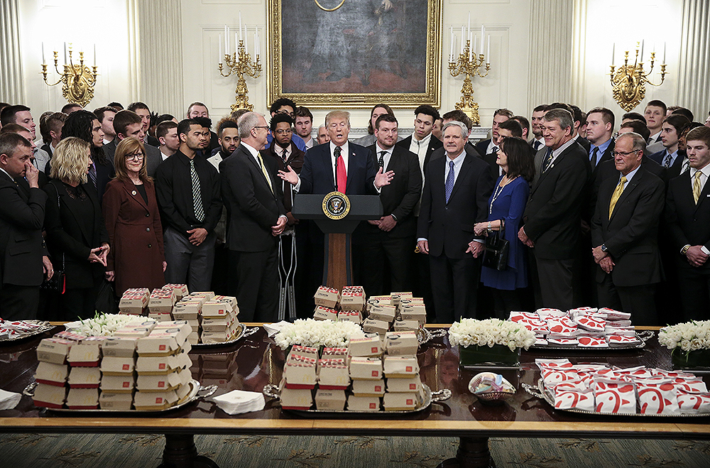 President Donald Trump speaks behind a table full of McDonald's hamburgers, Chick fil-a sandwiches and some other fast food as he welcomes the 2018 Division I FCS National Champions: The North Dakota State Bison in the State Dining Room of the White House on March 4, 2019 in Washington, DC. (Photo by Oliver Contreras/SIPA USA)(Sipa via AP Images)