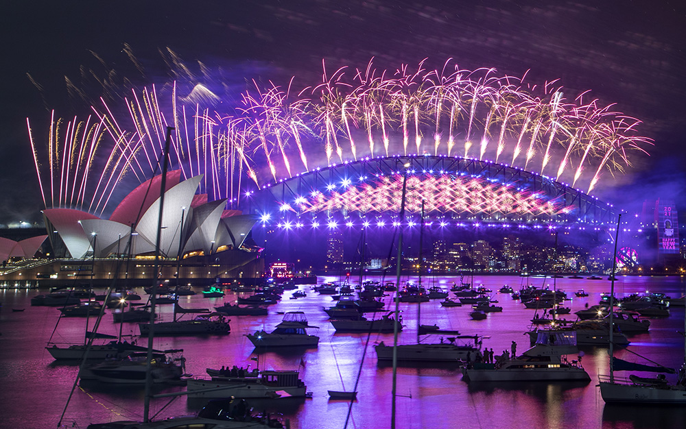 Fireworks explode over the Sydney Opera House and Harbour Bridge as New Year celebrations begin in Sydney, Australia, Thursday, Dec. 31, 2020. One million people would usually crowd the Sydney Harbor to watch the annual fireworks that center on the Sydney Harbour Bridge. But this year authorities advised revelers to watch the fireworks on television as the two most populous states, New South Wales and Victoria battle to curb new COVID-19 outbreaks. (AP Photo/Mark Baker)