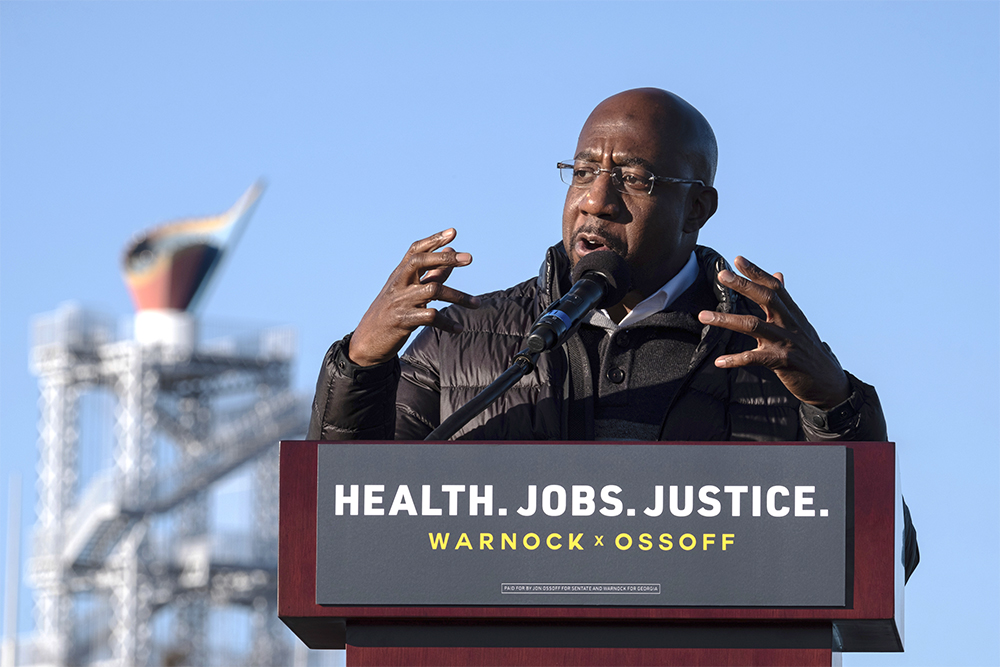 Democratic Georgia Senate challenger the Rev. Raphael Warnock addresses supporters during a rally with Jon Ossoff in Atlanta on the first day of early voting for the senate runoff Monday, Dec. 14, 2020. (AP Photo/Ben Gray)