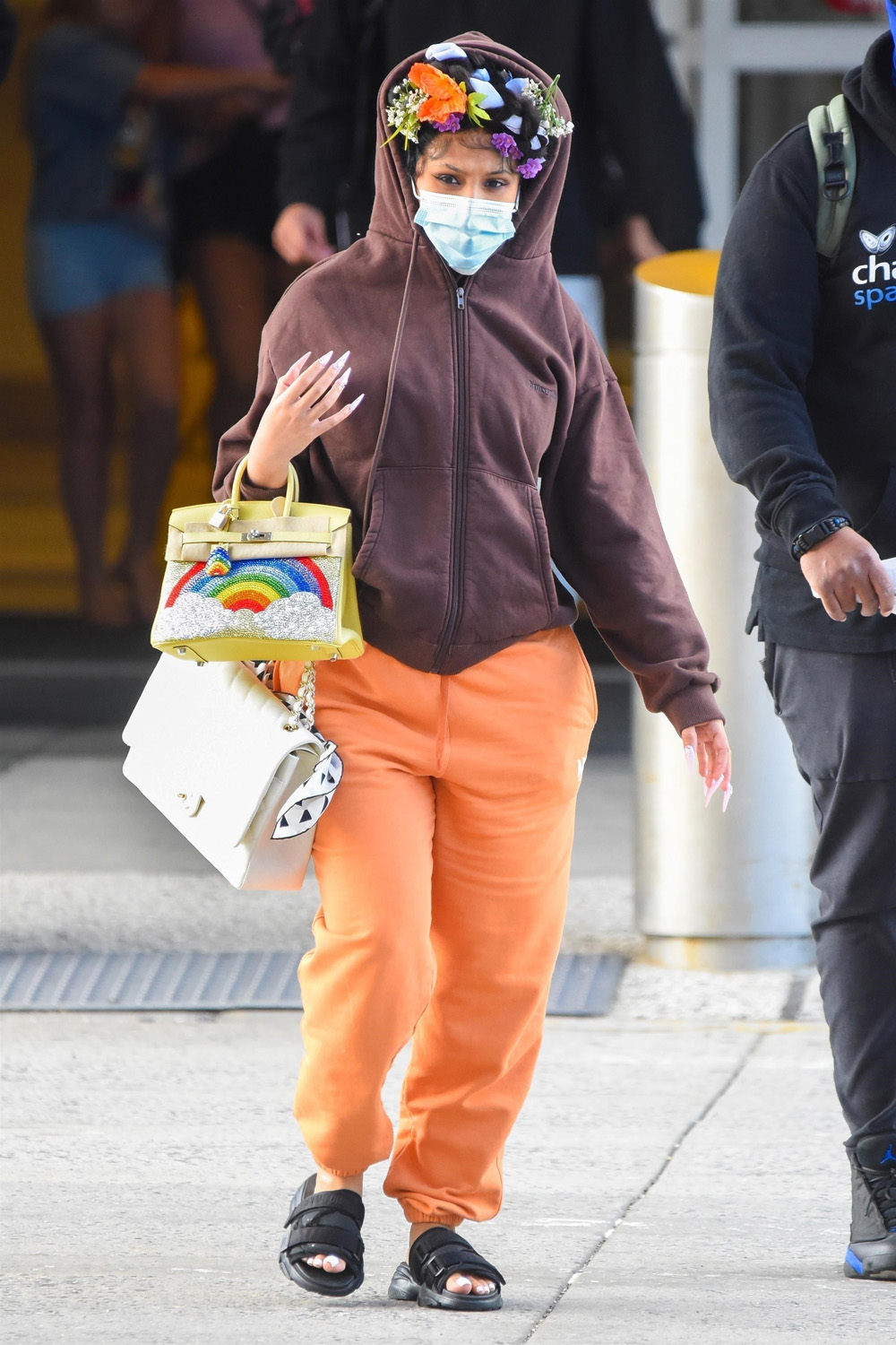 New York, NY  - *EXCLUSIVE*  - A pregnant Cardi B wearing a floral headband and a brown hoodie and orange sweat pants carries two designer handbags as she arrives at JFK Airport in NYC.

Pictured: Cardi B

BACKGRID USA 9 JULY 2021 

USA: +1 310 798 9111 / usasales@backgrid.com

UK: +44 208 344 2007 / uksales@backgrid.com

*UK Clients - Pictures Containing Children
Please Pixelate Face Prior To Publication*