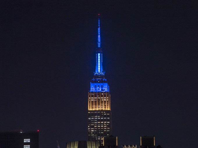 The Empire State Building Lit Up In Blue And Yellow