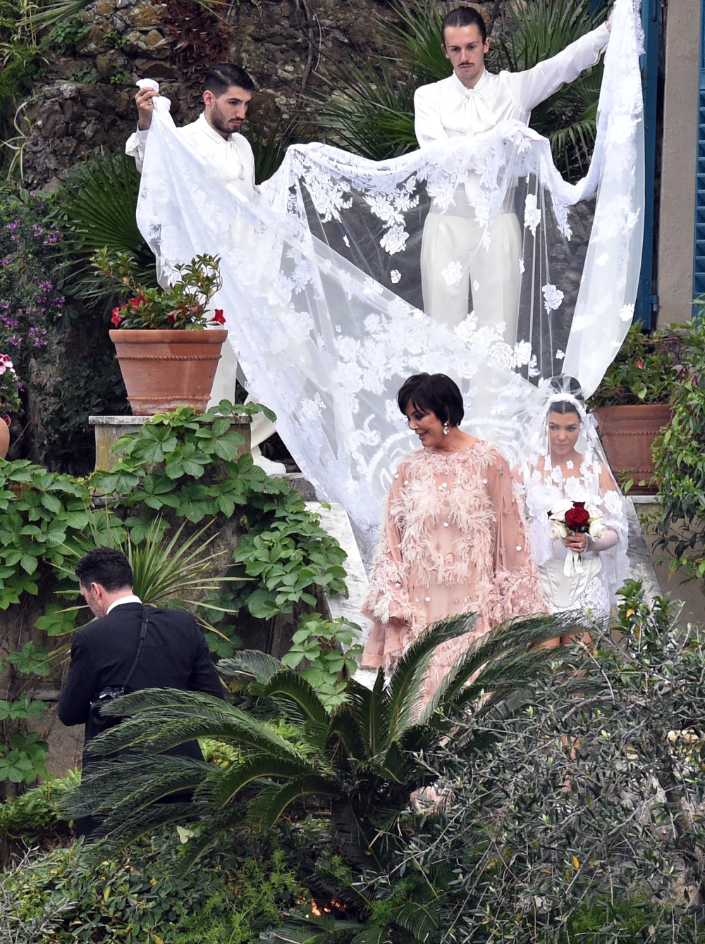 *EXCLUSIVE* Kourtney Kardashian is seen being guided to her wedding by mother Kris.