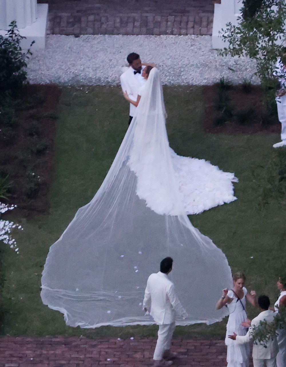 Savannah, GA  - *PREMIUM-EXCLUSIVE*  - And the bride wore… white. Jennifer Lopez wears a stunning white wedding dress as she celebrates her marriage to Ben Affleck, suitably dashing in a white jacket and black pants. The couple kissed and posed for pics around Ben’s $8million Georgia mansion on Saturday evening before spending the night celebrating their love and their union with family and a raft of A-list friends. All the couple’s children from their new blended family were also spotted on a walkway leading to Ben’s plantation style house with two of the boys carrying J Lo, now Jennifer Affleck’s, incredible train.

Pictured: Ben Affleck and Jennifer Lopez

BACKGRID USA 20 AUGUST 2022 

USA: +1 310 798 9111 / usasales@backgrid.com

UK: +44 208 344 2007 / uksales@backgrid.com

*UK Clients - Pictures Containing Children
Please Pixelate Face Prior To Publication*