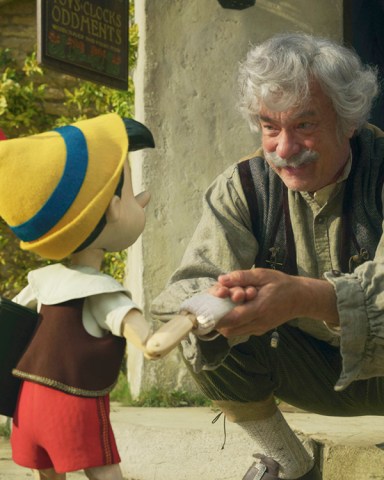 (L-R): Pinocchio (voiced by Benjamin Evan Ainsworth), Tom Hanks as Geppetto, and Figaro in Disney's live-action PINOCCHIO, exclusively on Disney+. Photo courtesy of Disney Enterprises, Inc. © 2022 Disney Enterprises, Inc. All Rights Reserved.