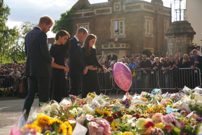 The royal family members look at the tribute