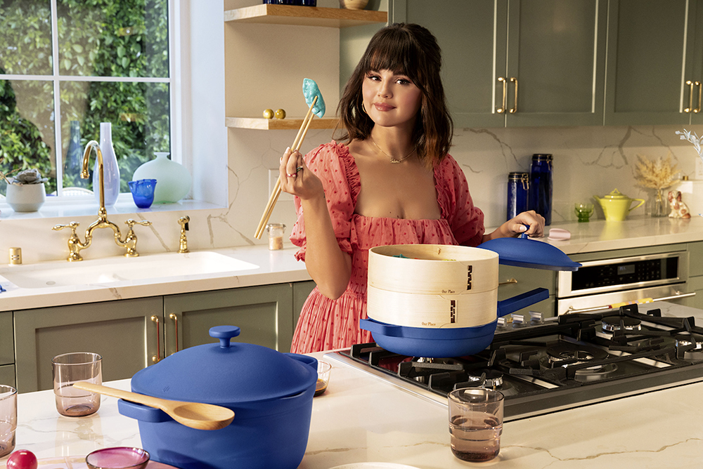 Selena Gomez is helping fans cook up a storm by launching a colorful kitchenware collection aimed at bringing families together through home-cooked meals. The singer and actress has teamed up with trendy cookware brand Our Place on a collection products, including a bold new look for the brand’s signature “Always Pan” and “Perfect Pot”. The Our Place x Selena Gomez collection also includes a knife trio, drinking glasses, main plates and side plates in two new limited edition colors - a bright electric blue called Azul and a deep, vibrant berry pink called Rosa. Selena and Our Place co-founder Shiza Shahid say they bonded over a shared belief that people can come together and connect with their heritage through home-cooked meals. Selena said: “This collection is a celebration of all the ways that we slow down and enjoy time in the kitchen: for those that cook perfectly or imperfectly, messily and joyously. “I hope people are inspired to stay in and connect with their family and friends over a meal. “For me, time in the kitchen and cooking have always been some of the most memorable, bonding moments.” Selena has put her cooking skills on display in her HBO Max cooking show “Selena + Chef” and says doing the show has taught her a lot. Our Place will donate 10% of net proceeds from the collaboration to the Rare Impact Fund, launched by Selena’s Rare Beauty cosmetics brand in 2020. The Rare Impact fund aims to support organizations working to increase access to mental health services in schools, and has set a target to raise $100 million over the next 10 years. *BYLINE: Our Place/Mega. 13 May 2022 Pictured: Selena Gomez launches new kitchenware collection with Our Place. *BYLINE: Our Place/Mega. Photo credit: Our Place/Mega TheMegaAgency.com +1 888 505 6342 (Mega Agency TagID: MEGA857176_004.jpg) [Photo via Mega Agency]