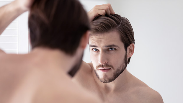 Man looking at his reflection in the mirror