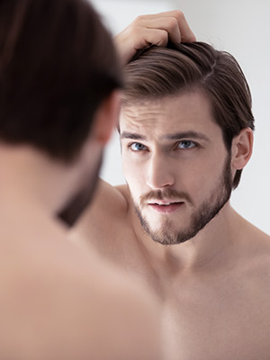 Man looking at his reflection in the mirror
