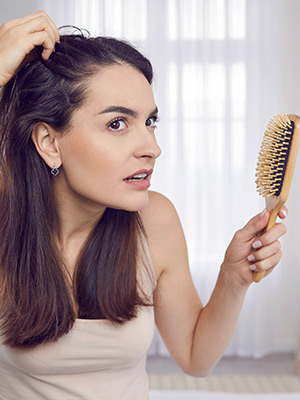 Woman examining her scalp