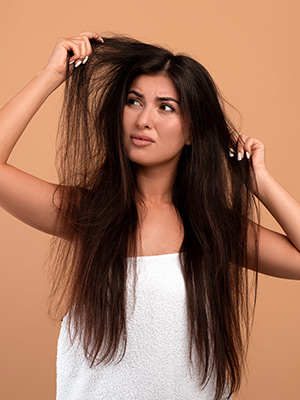 Woman looking at her dry hair