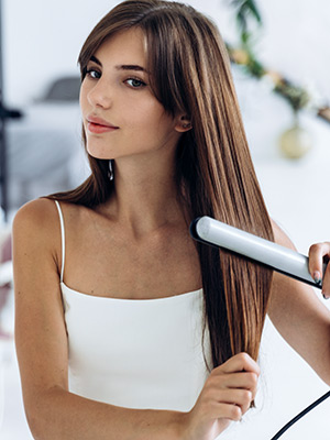 Woman straightening her hair