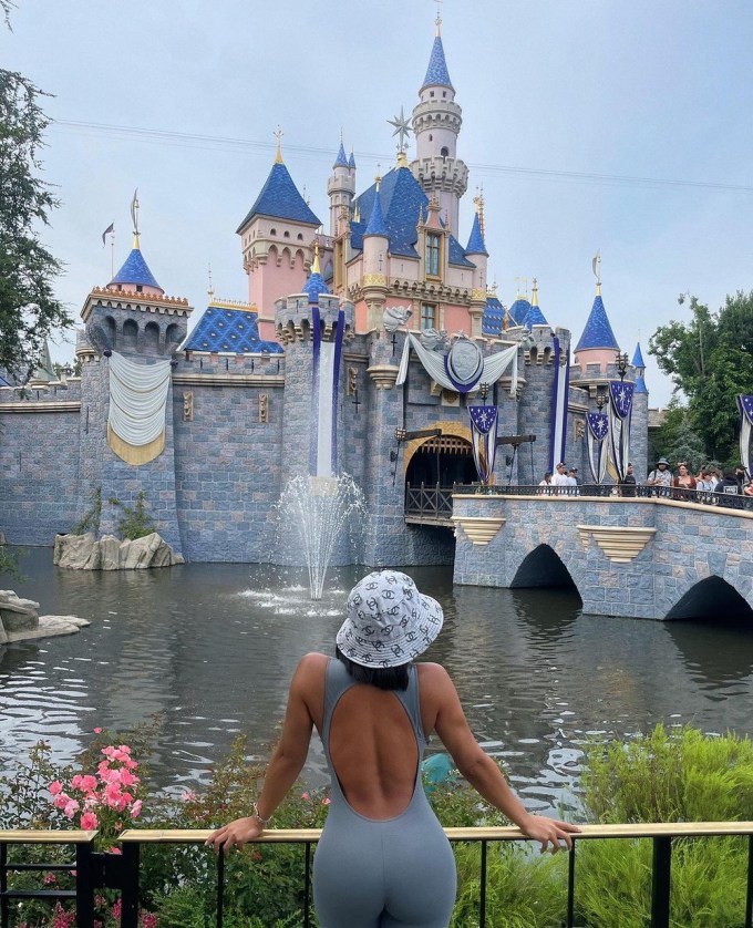 Lori Harvey in front of the Sleeping Beauty Castle