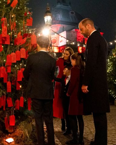 LONDON, ENGLAND - DECEMBER 06:  The Prince and Princess of Wales with their children Prince George, Princess Charlotte and Prince Louis look at messages on the Kindness Tree ahead  of the Together At Christmas carol service at Westminster Abbey on December 6, 2024 in London, England. The Prince and Princess of Wales, along with other members of the Royal Family, attended the annual carol service. Led by The Princess and supported by The Royal Foundation, the event offered a chance to pause and reflect on the profound values of love, compassion, and the vital connections we share—particularly during life's most challenging moments. The service also highlighted remarkable individuals from across the UK who have demonstrated extraordinary kindness, empathy, and support within their communities. (Photo by Jordan Pettitt - WPA Pool/Getty Images)