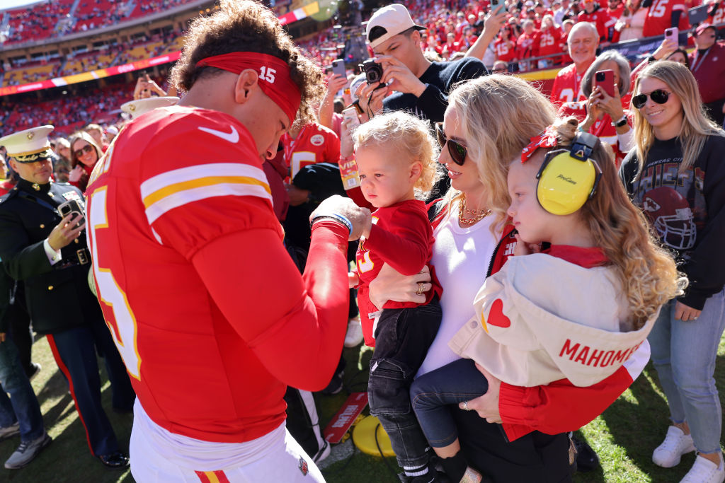 KANSAS CITY, MISSOURI - NOVEMBER 10: Patrick Mahomes #15 of the Kansas City Chiefs fist bumps his son, Bronze, while his wife and daughter, Brittany and Sterling, watch prior to a game against the Denver Broncos at GEHA Field at Arrowhead Stadium on November 10, 2024 in Kansas City, Missouri. (Photo by Jamie Squire/Getty Images)