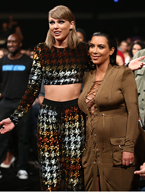 Taylor Swift and Kim Kardashian standing for a photo at the 2015 VMAs