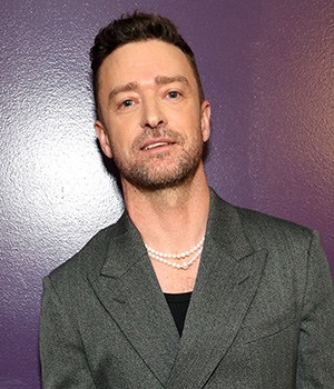 Justin Timberlake leaning against a purple wall