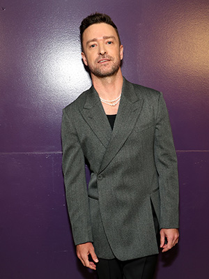Justin Timberlake leaning against a purple wall