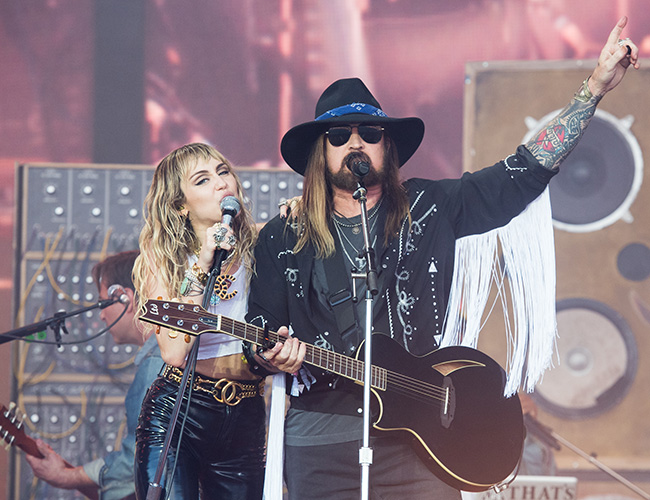 Miley Cyrus and Billy Ray Cyrus performing on stage