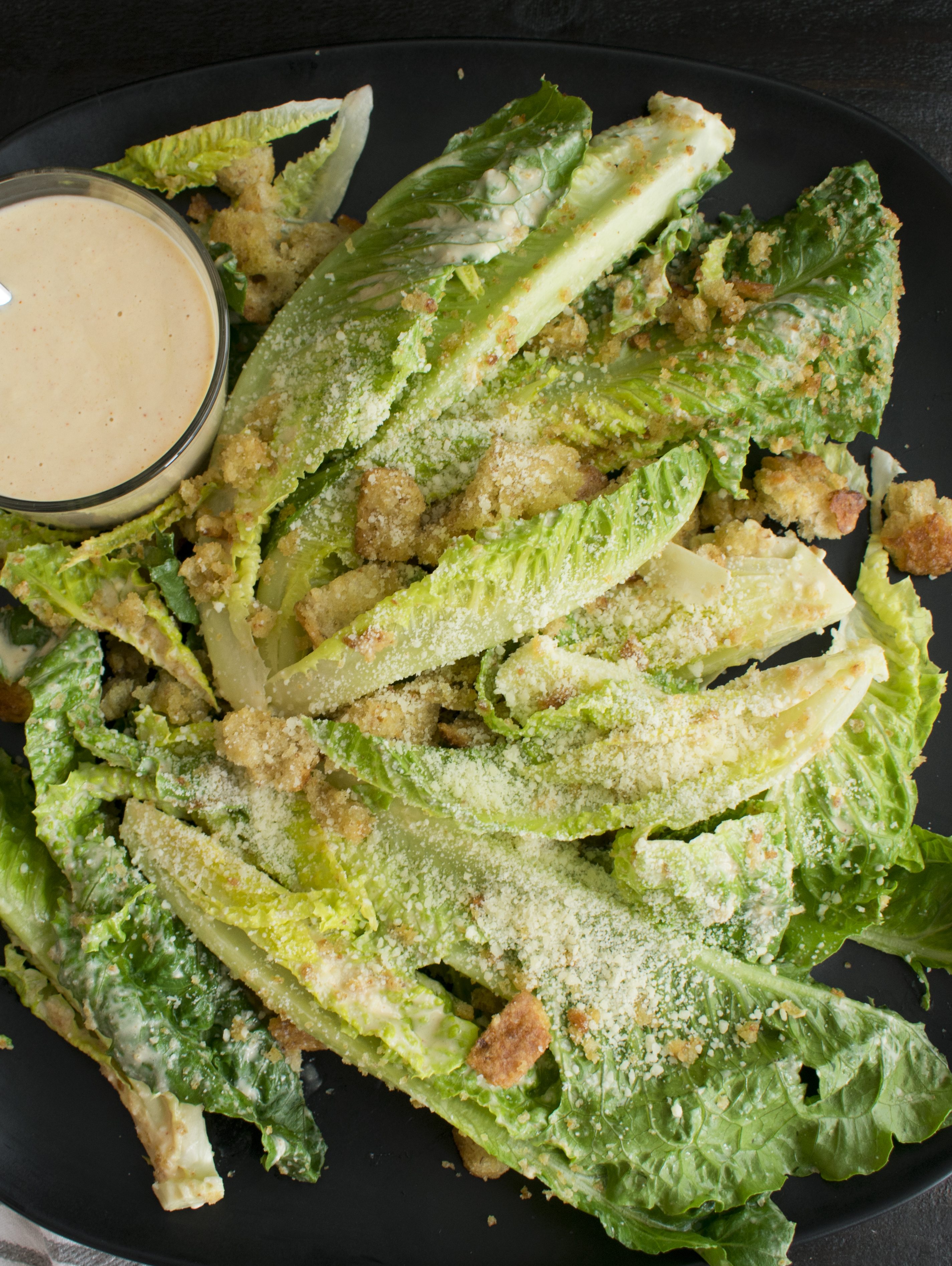 Caesar salad and dressing on a serving plate