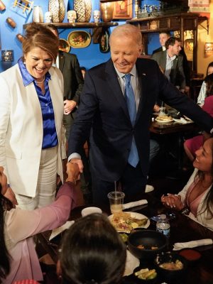 TOPSHOT - US President Joe Biden, alongside Maritza Rodriguez (in white), a campaign advisor for the Biden Nevada state team, greets people as he arrives at Lindo Michoacan restaurant ahead of a radio interview in Las Vegas, Nevada, on July 17, 2024.  (Photo by Kent Nishimura / AFP) (Photo by KENT NISHIMURA/AFP via Getty Images)