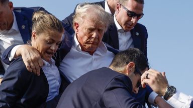 BUTLER, PENNSYLVANIA - JULY 13: Republican presidential candidate former President Donald Trump is rushed offstage by U.S. Secret Service agents after being grazed by a bullet during a rally on July 13, 2024 in Butler, Pennsylvania. Butler County district attorney Richard Goldinger said the shooter is dead after injuring former U.S. President Donald Trump, killing one audience member and injuring another in the shooting. (Photo by Anna Moneymaker/Getty Images)