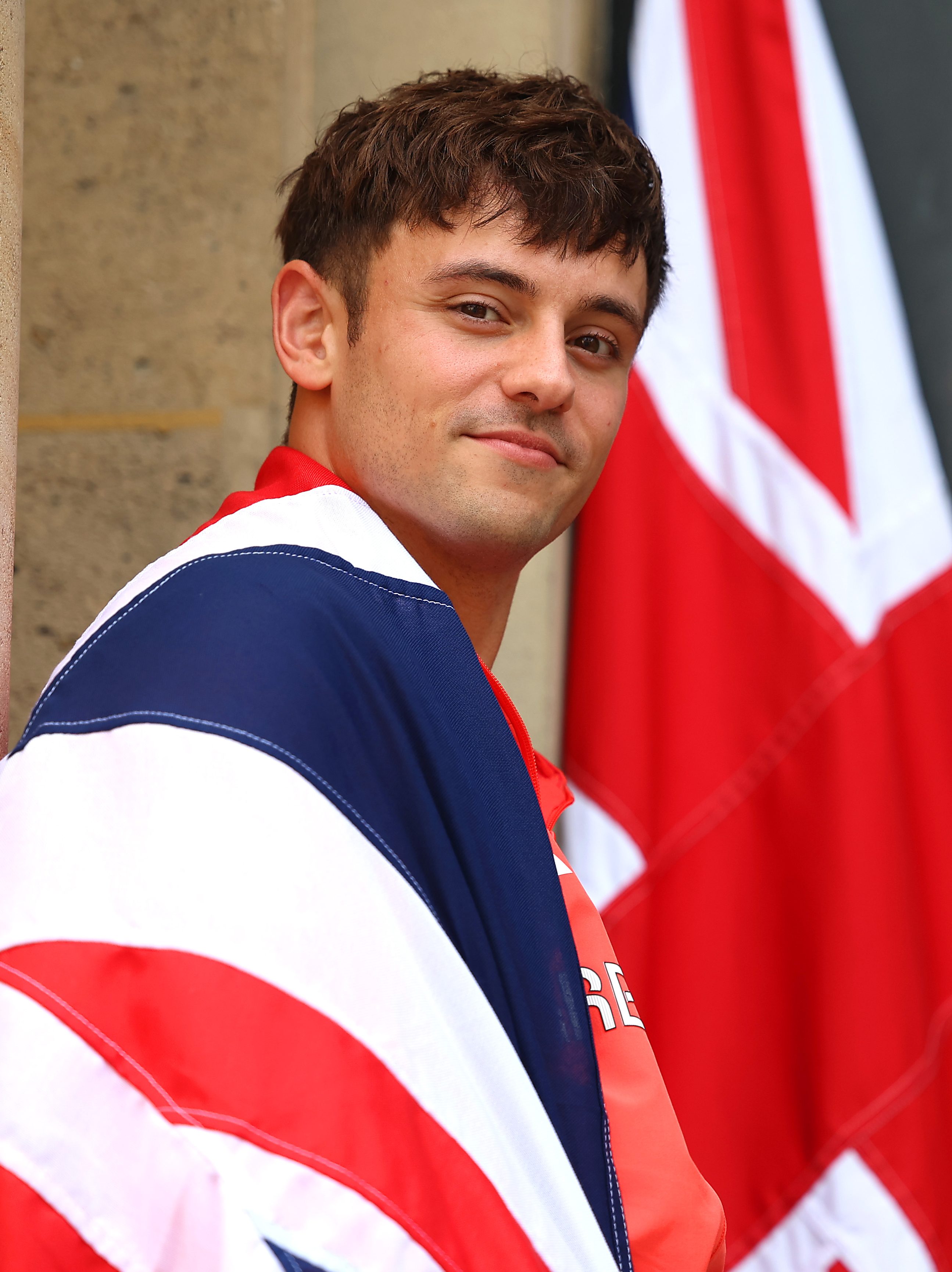 Tom Daley of Team Great Britain poses with his national flag