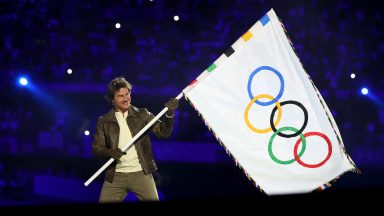 Tom Cruise holds the Olympic flag during the Closing Ceremony of the Olympic Games Paris 2024 at Stade de France on August 11, 2024 in Paris, France. (Photo by Fabrizio Bensch- Pool/Getty Images)