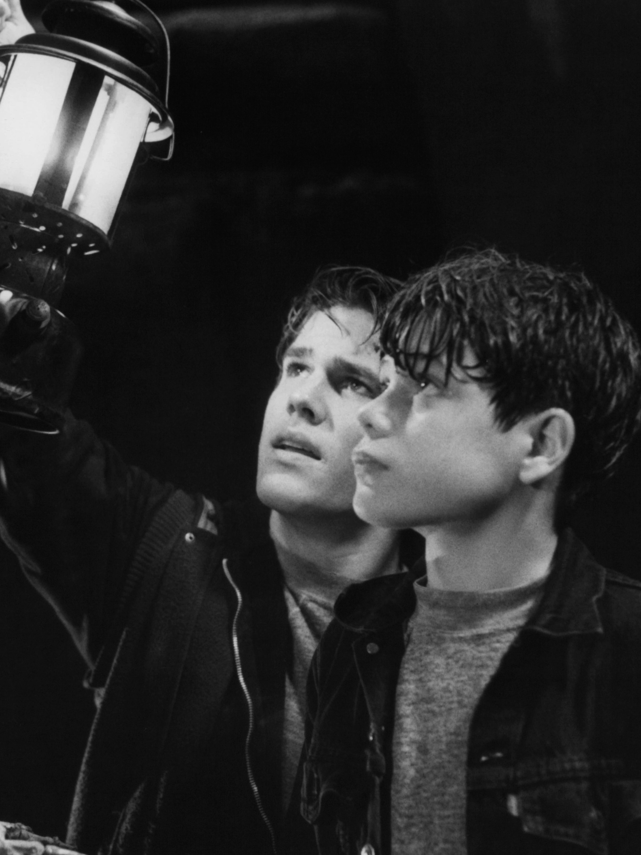 Josh Brolin and Sean Astin holding up light to bones in a scene from the film 'Goonies'