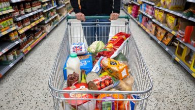 CARDIFF, WALES - MAY 22: A woman with a shopping trolley full of groceries in a supermarket aisle on May 22, 2022 in Cardiff, Wales. Last week, the UK Office for National Statistics reported an 6% average increase of food and drink prices year on year, but some staples, such as milk and pasta, had risen by more than 10%. (Photo by Matthew Horwood/Getty Images)