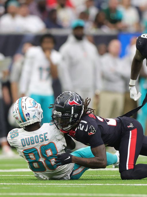 HOUSTON, TEXAS - DECEMBER 15: Grant DuBose #88 of the Miami Dolphins is hit by Calen Bullock #21 of the Houston Texans during the third quarter at NRG Stadium on December 15, 2024 in Houston, Texas. (Photo by Alex Slitz/Getty Images)