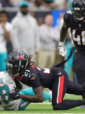 HOUSTON, TEXAS - DECEMBER 15: Grant DuBose #88 of the Miami Dolphins is hit by Calen Bullock #21 of the Houston Texans during the third quarter at NRG Stadium on December 15, 2024 in Houston, Texas. (Photo by Alex Slitz/Getty Images)