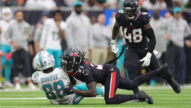 HOUSTON, TEXAS - DECEMBER 15: Grant DuBose #88 of the Miami Dolphins is hit by Calen Bullock #21 of the Houston Texans during the third quarter at NRG Stadium on December 15, 2024 in Houston, Texas. (Photo by Alex Slitz/Getty Images)